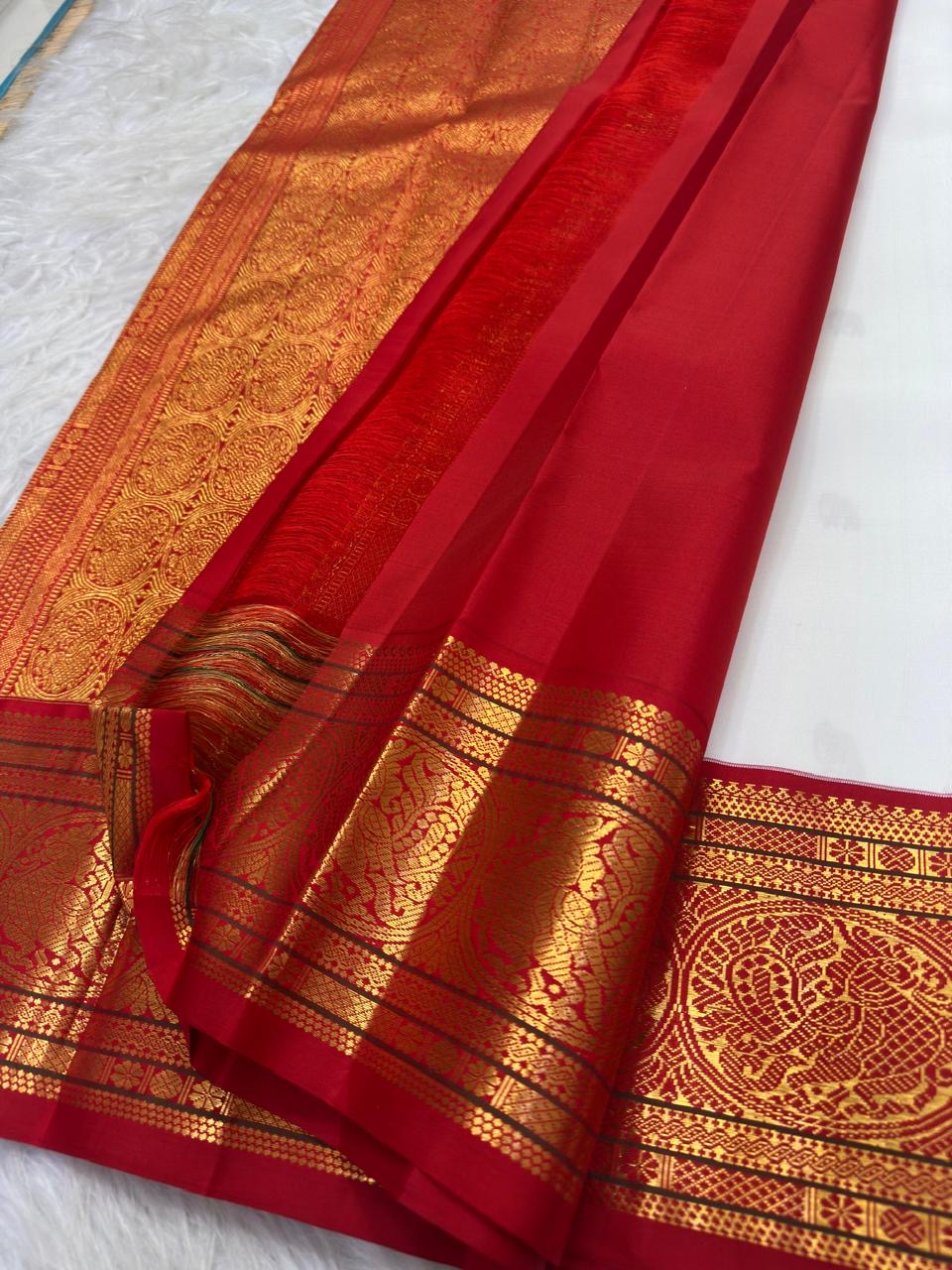 Warm ivory handwoven pure silk Kanchipuram Kai Korvai saree with gold zari flying horse buttas and temple-red border