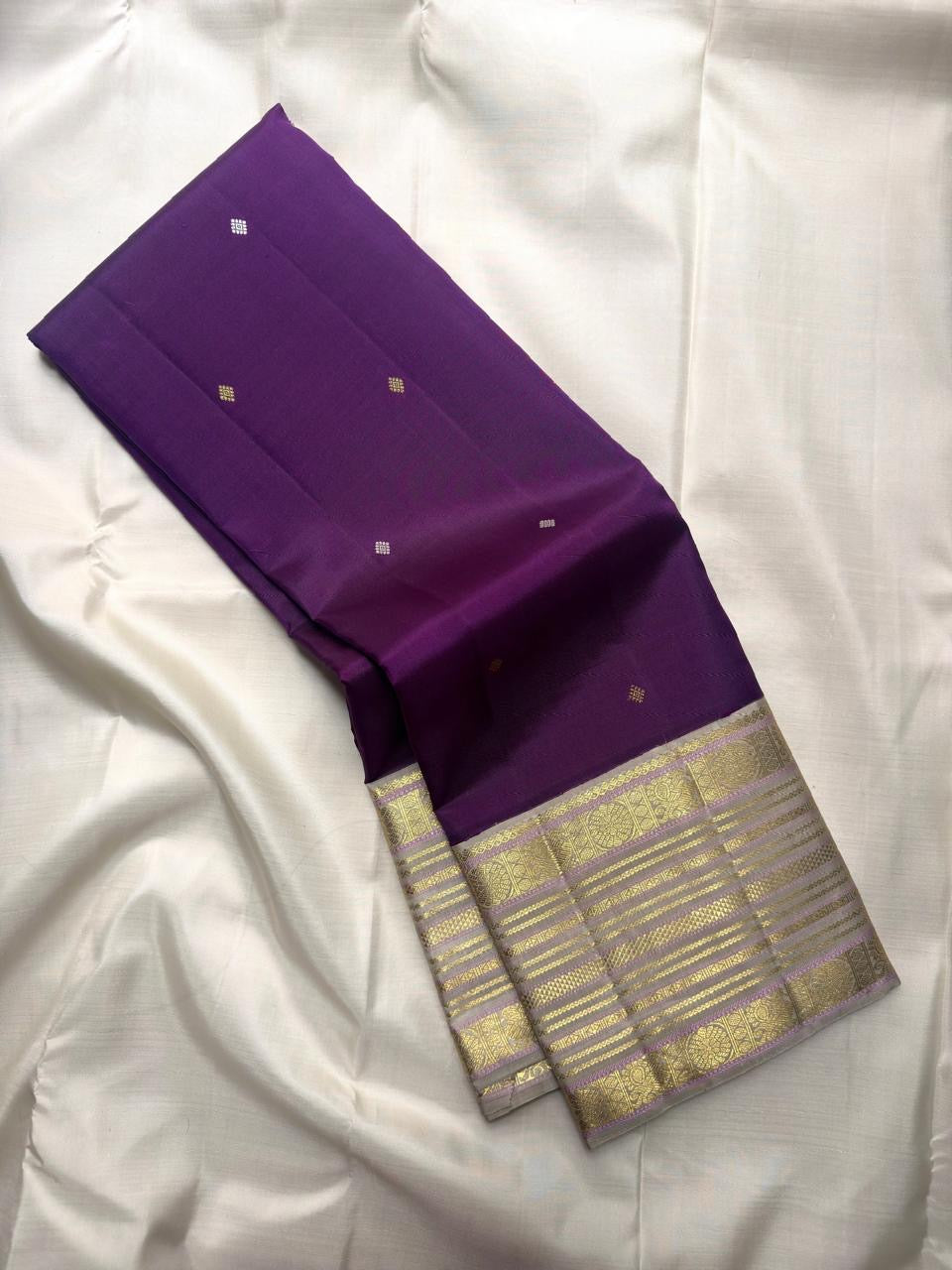 Close view of expansive sandalwood gold zari pallu with layered bands and lilac accents.