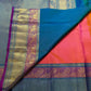 Close-up of the gold Zari Kattam grid weave on the coral-orange Kanchipuram silk saree
