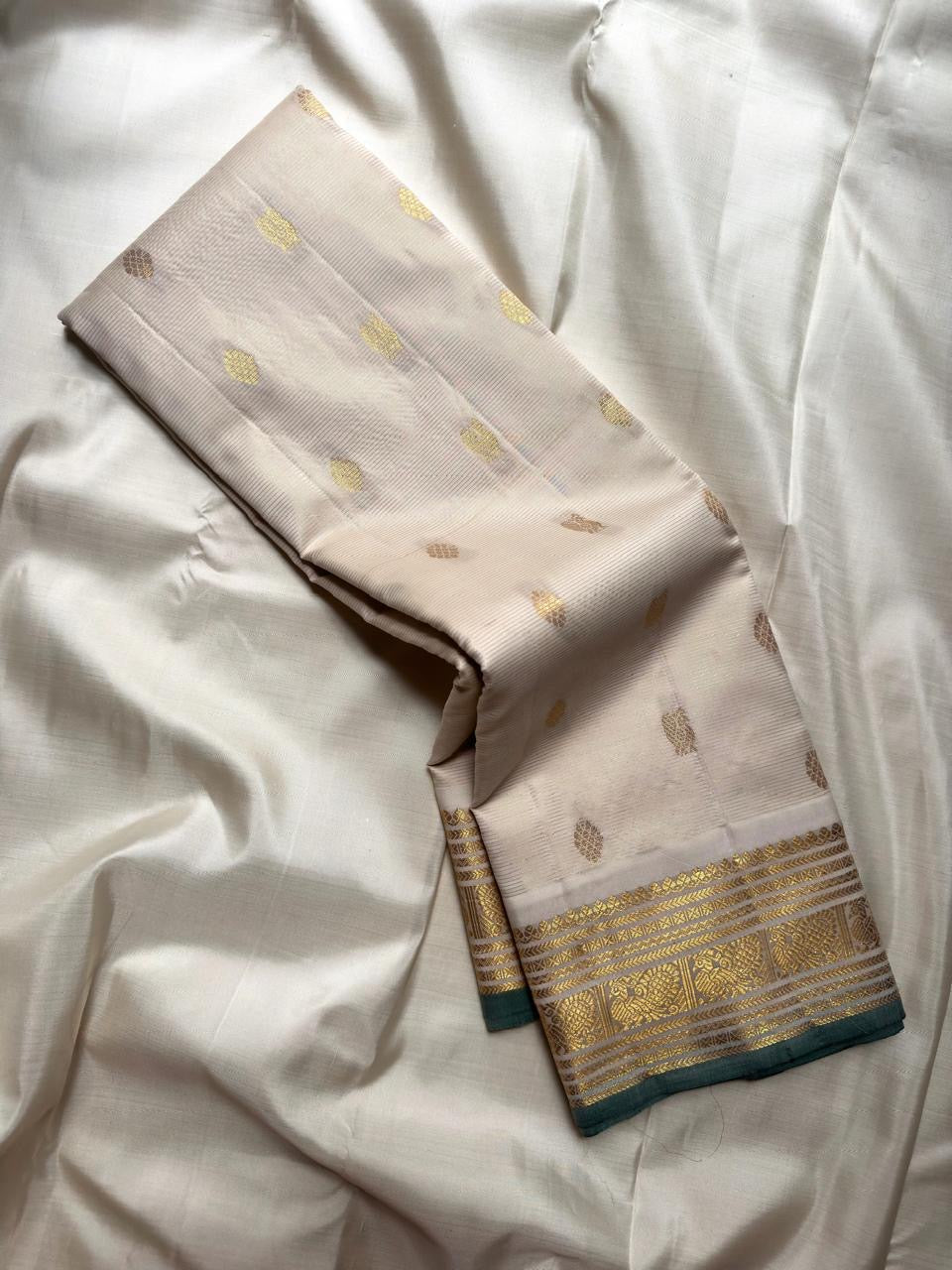 Ivory and Muted Green Pure Kanchipuram Silk Vairaoosi saree with fine zari lines, gold motifs and traditional peacock border