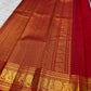 Vermilion red, warm Arakku-red undertones and rich yellow gold handwoven Kanchipuram butta silk saree, pallu full view, with gold zari detailing.