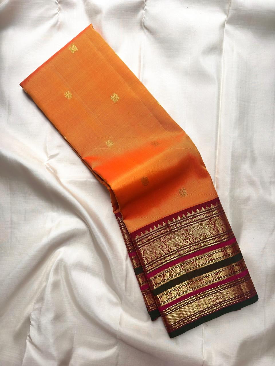 Marigold orange Varisaipet Kanchipuram saree with Arakku red border detail.