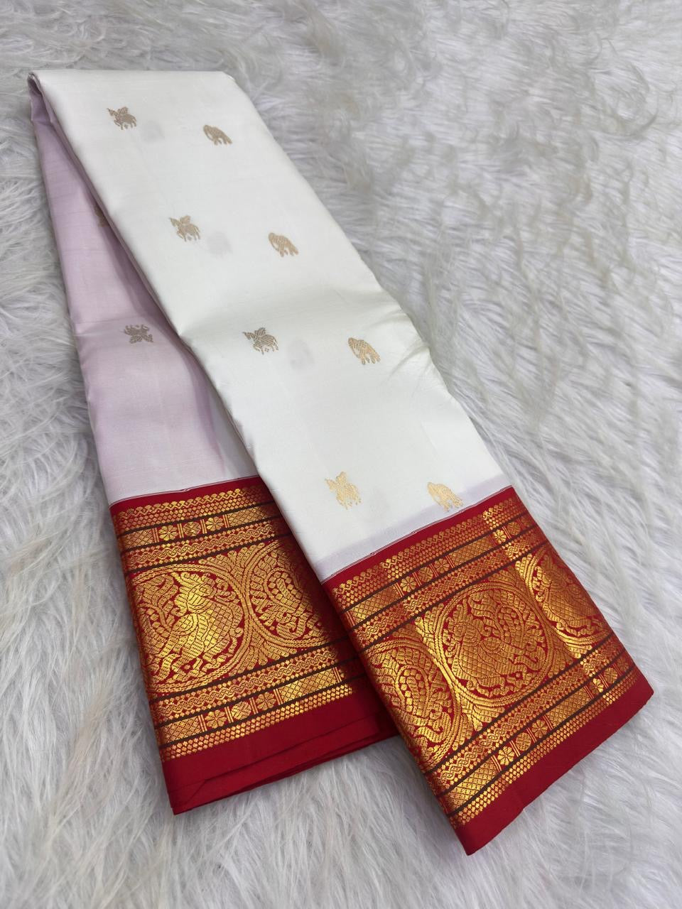 Warm ivory handwoven pure silk Kanchipuram Kai Korvai saree with gold zari flying horse buttas and temple-red border