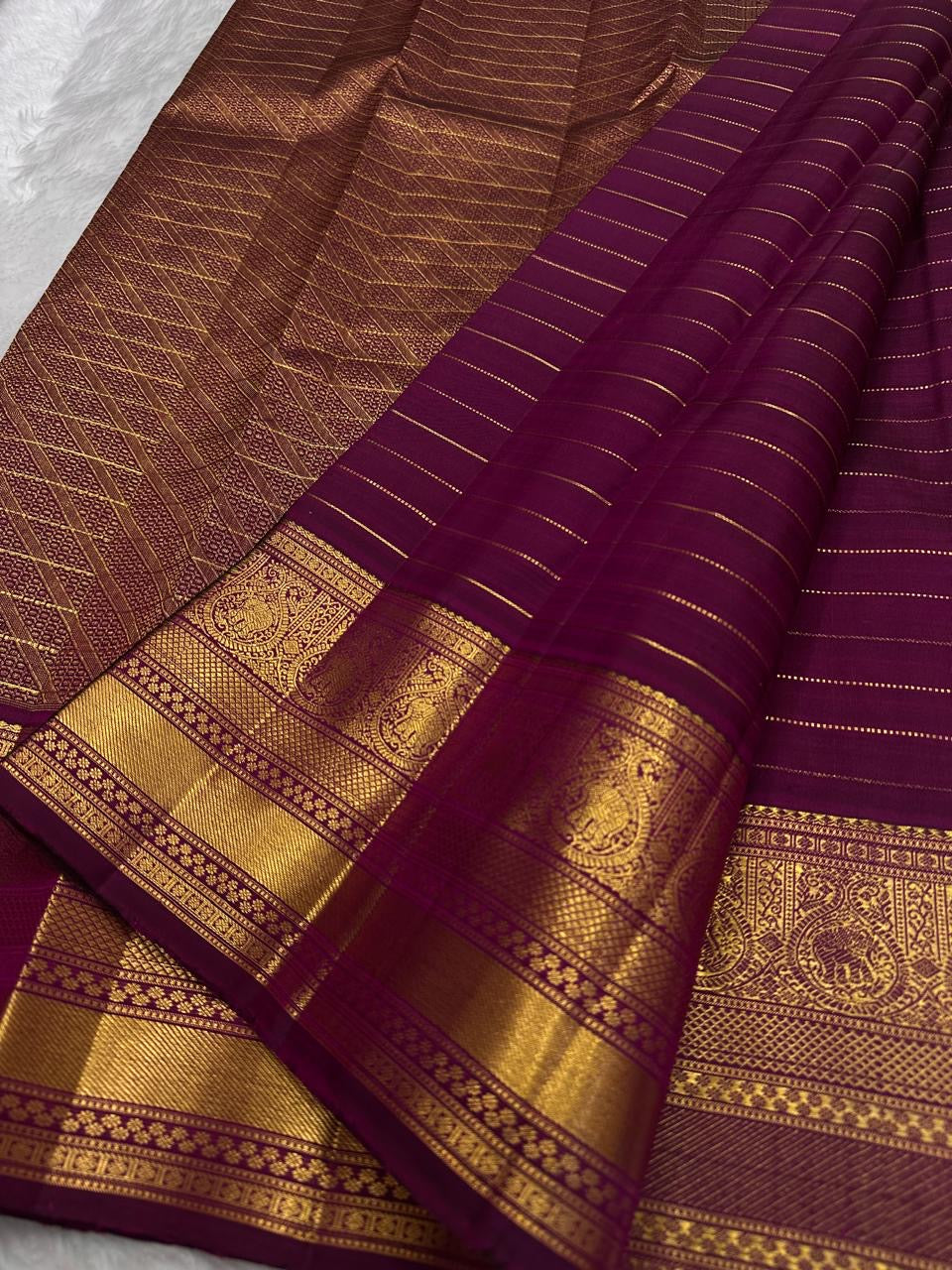 Pure silk Kanchipuram saree in deep berry purple with an elaborate antique gold zari pallu