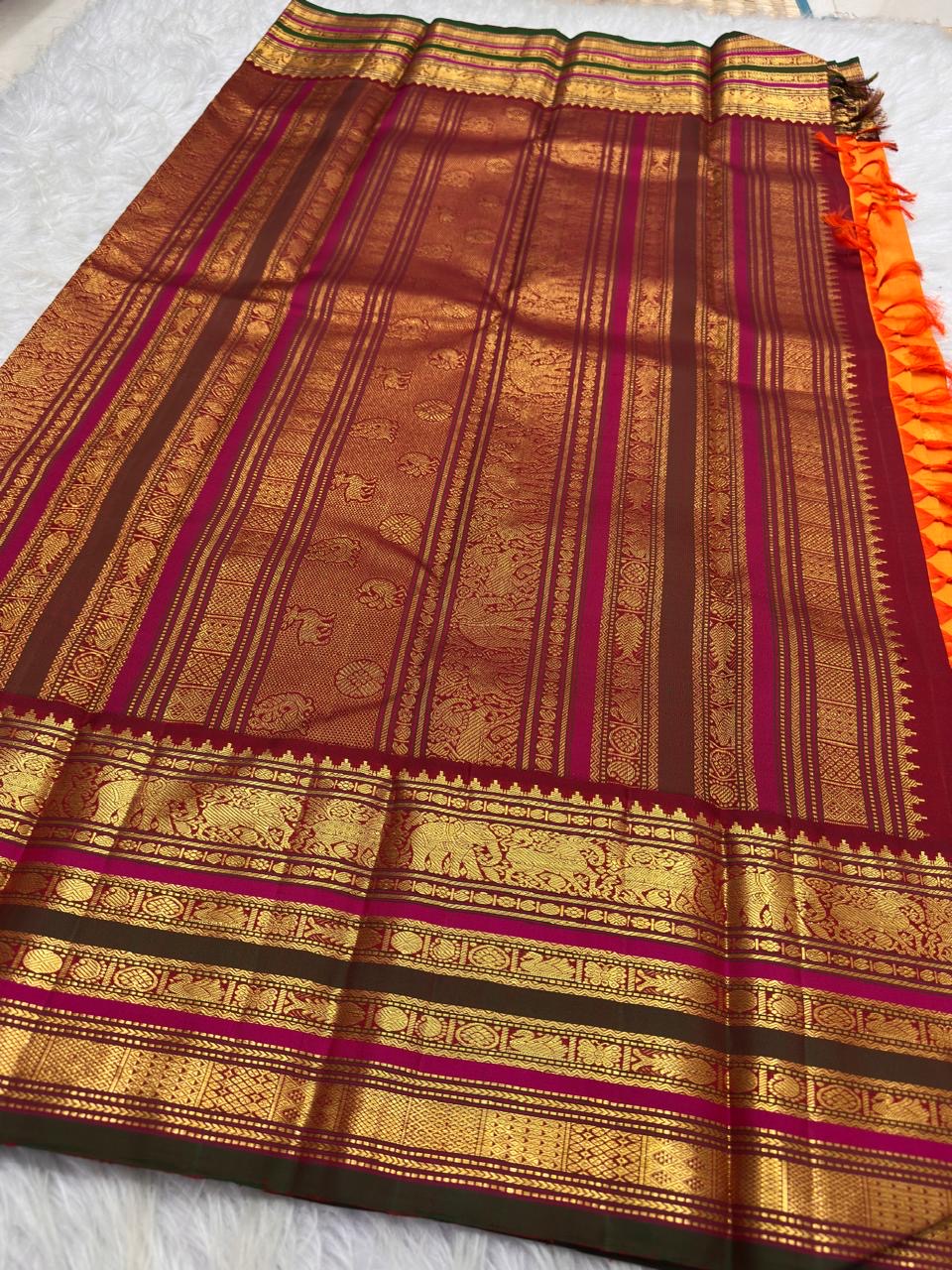 Marigold orange Kanchipuram saree with red and antique gold pallu.