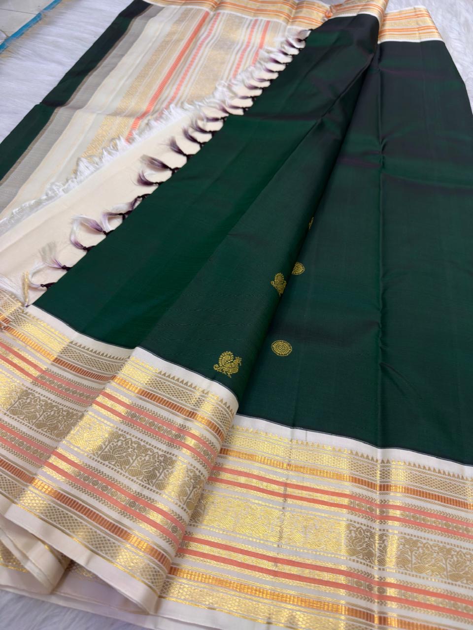 Warm Ivory & Deep Forest Green Pure Kanchipuram Silk Varisaipet saree showing traditional handwoven body and richly detailed border.