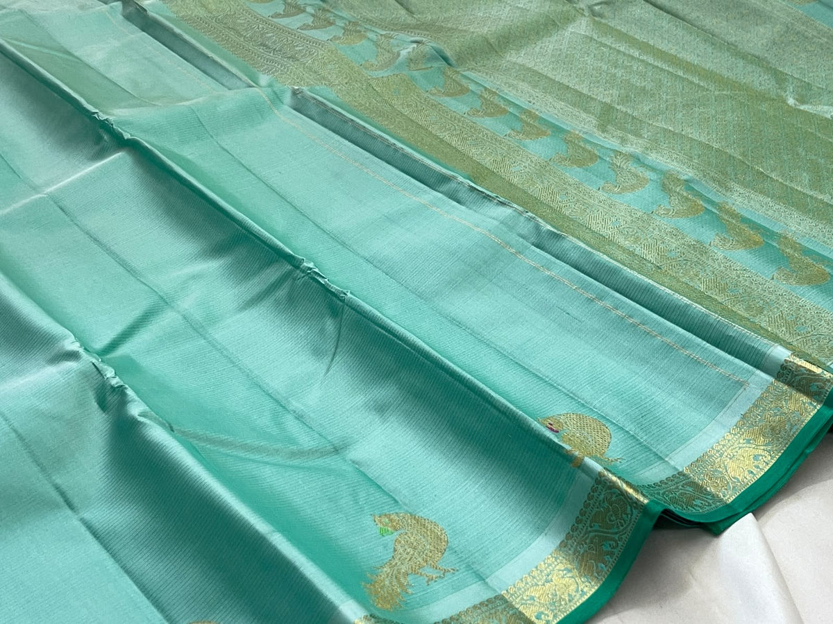 Sea glass turquoise Kanchipuram silk body with delicate handwoven zari peacock motifs spaced across fabric