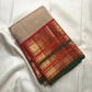 Sandalwood ivory Varisaipet Kanchipuram saree with Arakku red and emerald border detail.