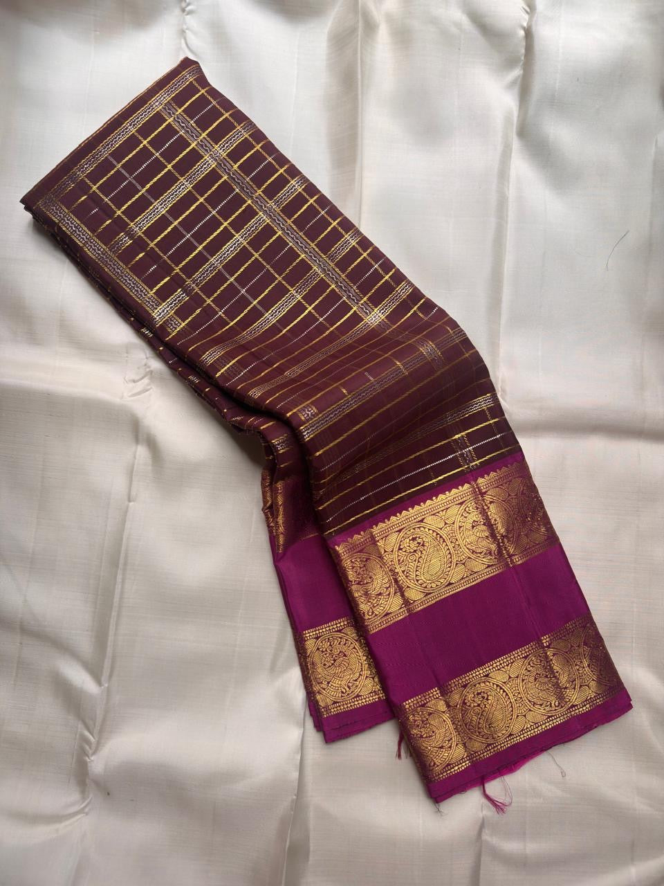 Oodha magenta Pure Kanchipuram Silk Zari Kattam saree with Rettapet border worn at a wedding-day temple ceremony