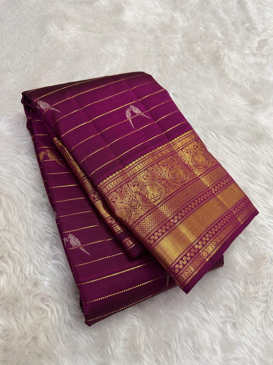Handwoven Kanchipuram saree in Naval Pazham purple with alternating silver and gold twin bird motifs