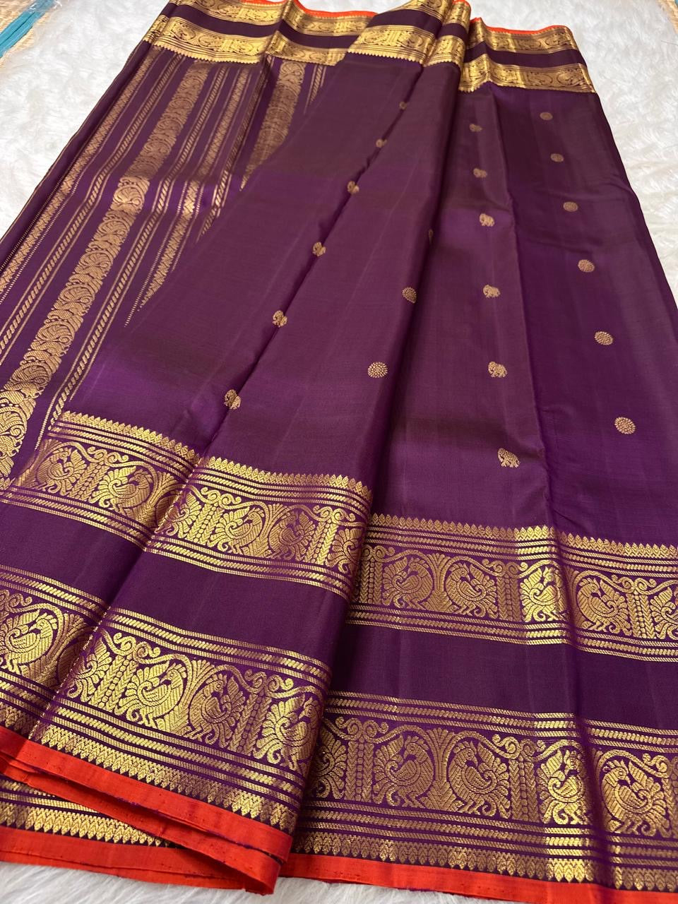 Peacock feather border detail woven in gold zari on deep purple Kanchipuram silk
