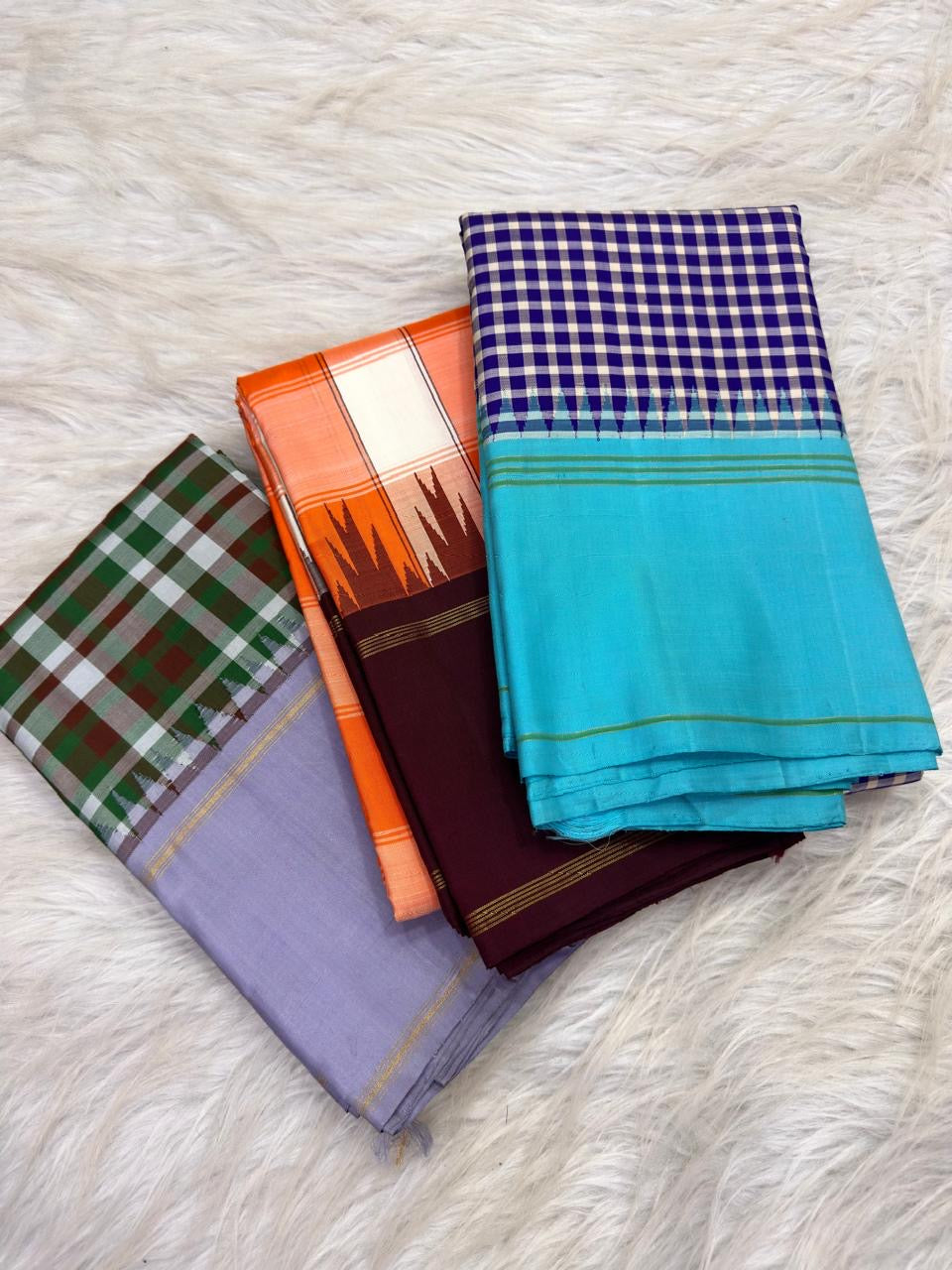 Kesari Orange Ivory Kanchi Kattam pure silk saree with deep purple border, worn for an anniversary vow ceremony.