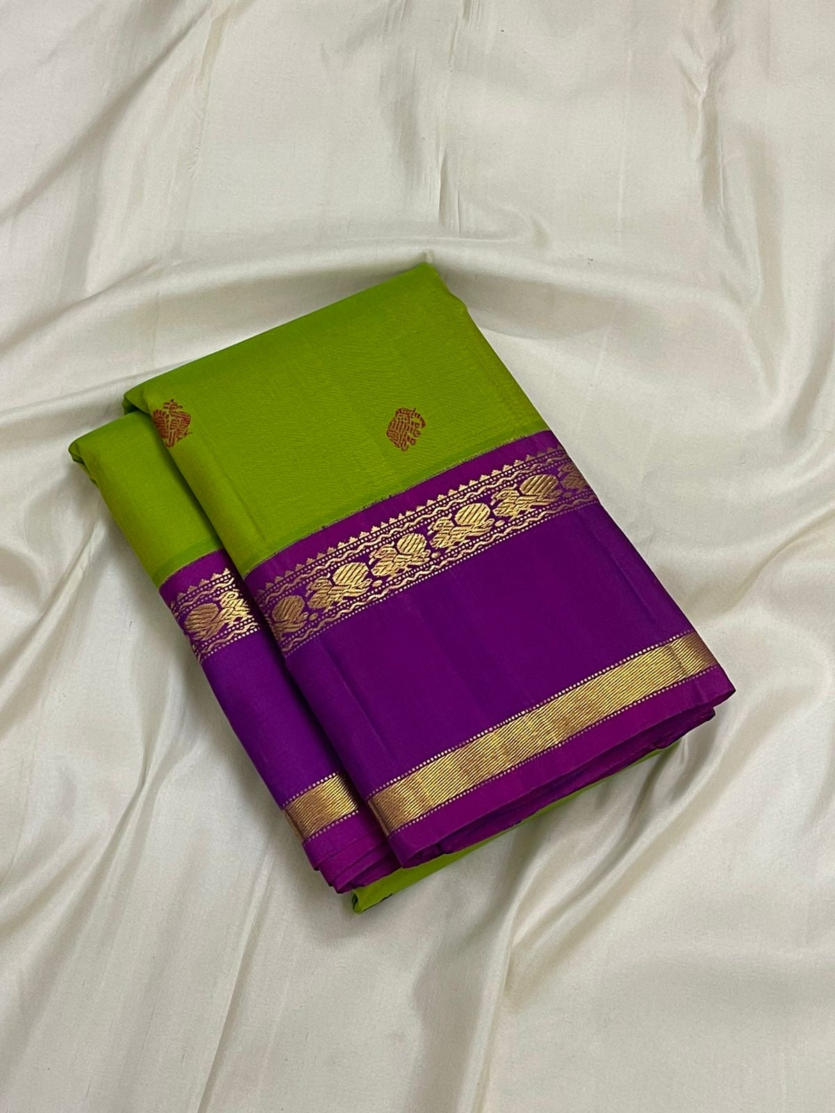 Kancheepuram silk saree bright green body with antique gold zari motifs and violet border close view