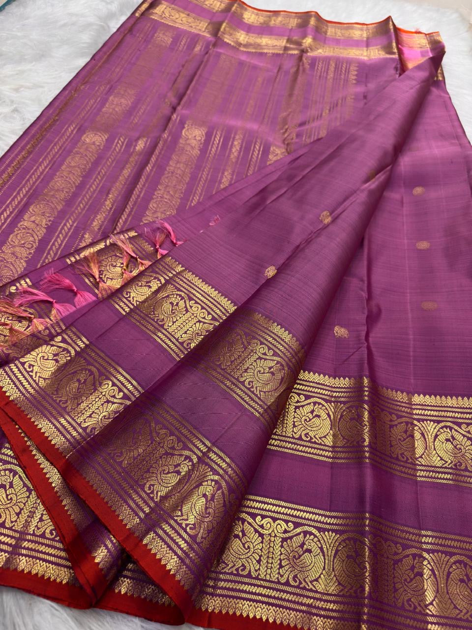 Close view of antique-gold zari pallu pattern on rose pink purple pure silk Kanchipuram Rettapet saree