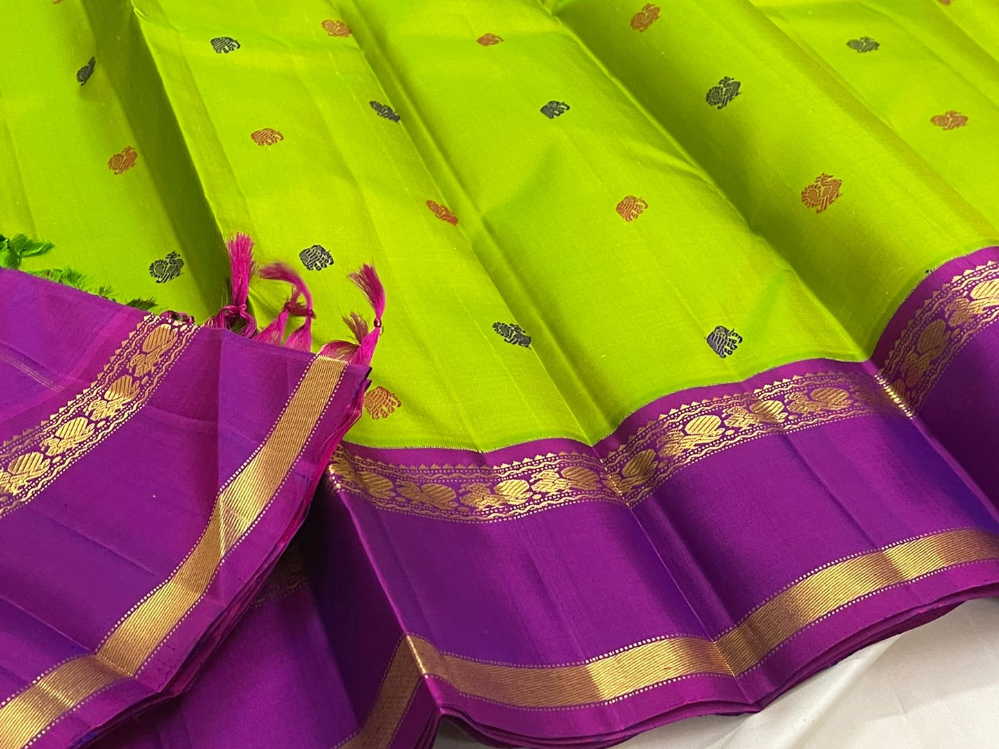 Kanchipuram silk saree vivid green with peacock motifs and violet zari border pallu detail