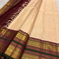 Soft peach ivory Kanchi Pattu silk saree with maroon and forest green border detail.