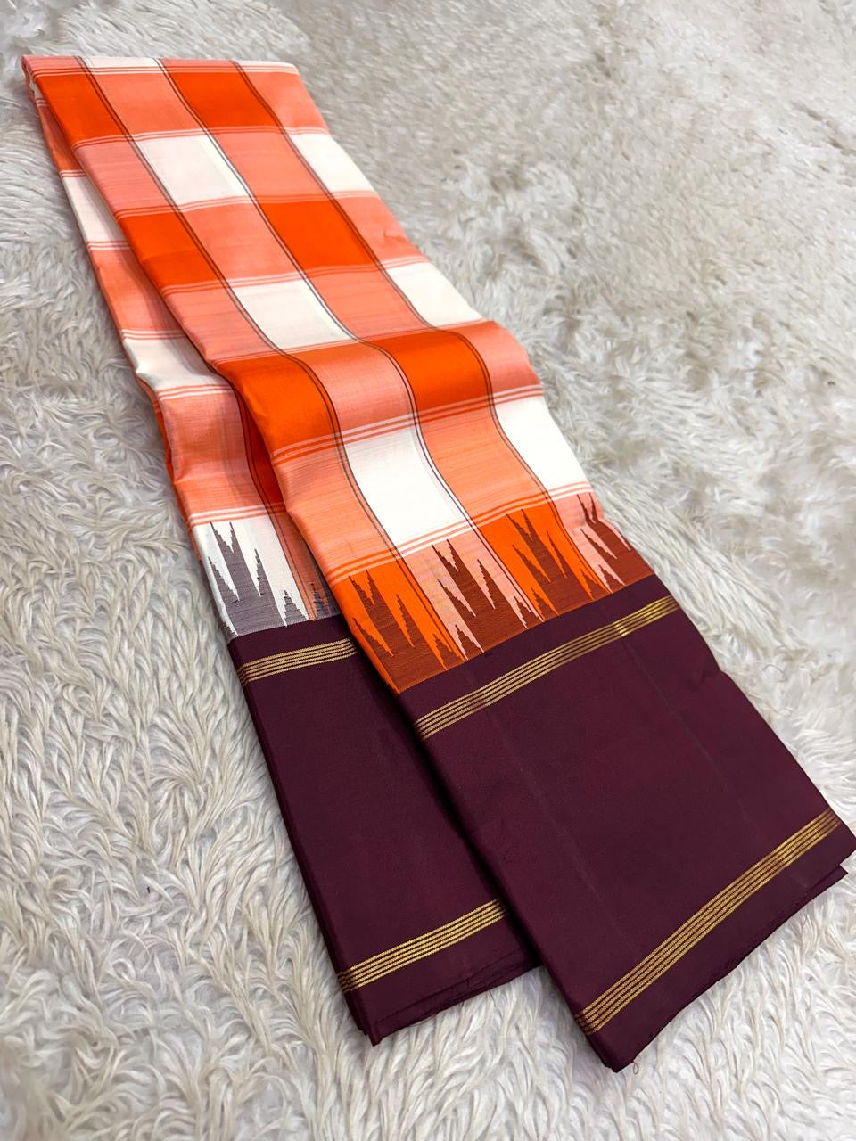 Kesari orange and ivory Kanchi Kattam Kanjivaram silk saree with deep purple border and gold zari, styled for a 21st birthday celebration.