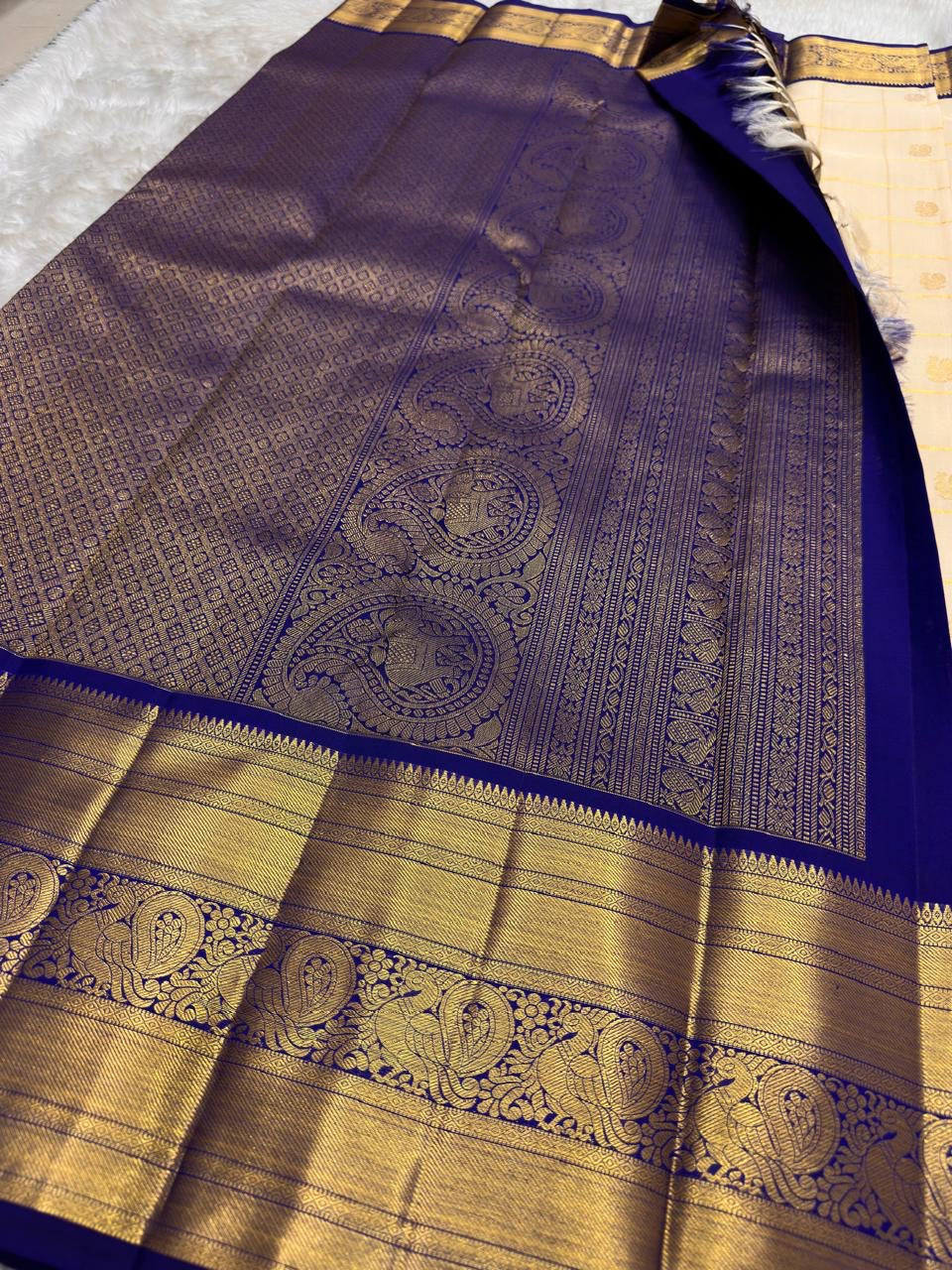 Deep Karu Neelam border with Mayil and Annam-style bird motifs woven in luminous classic gold zari.