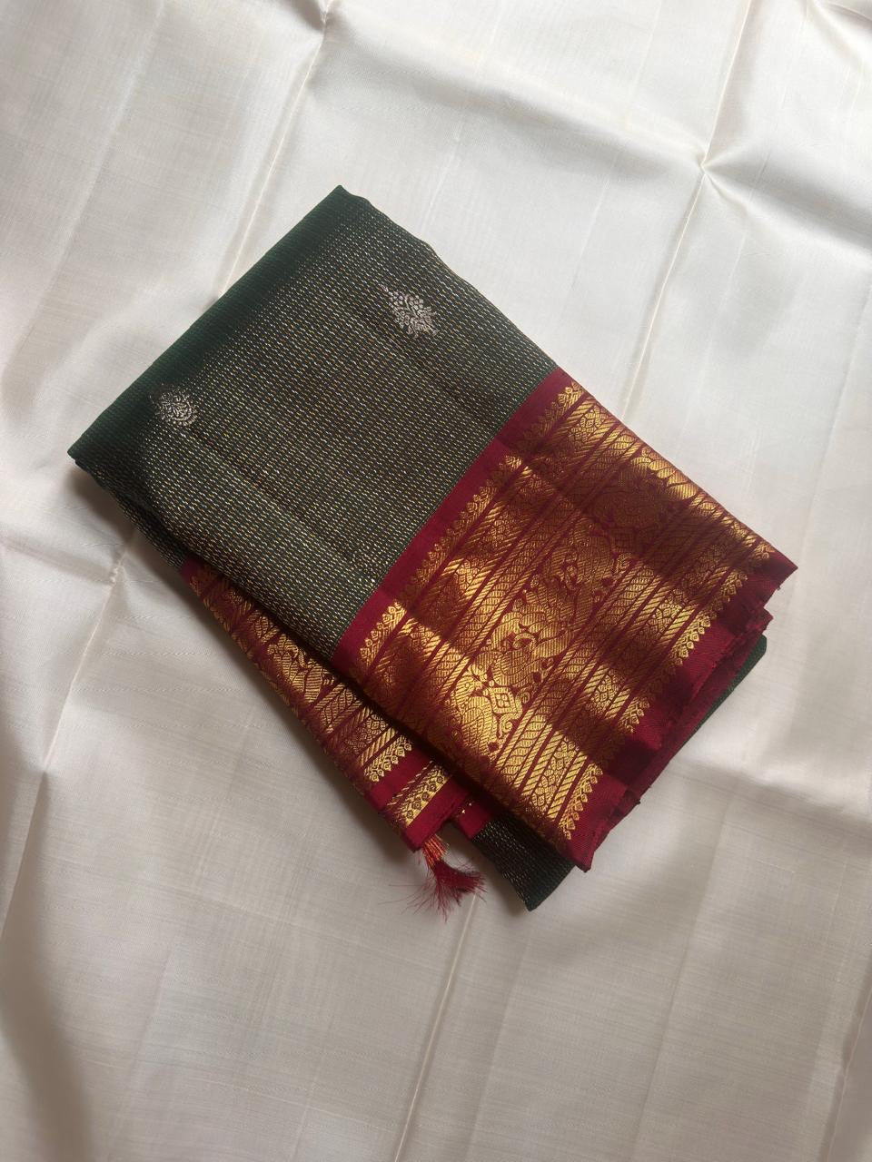 Close detail of dual-tone gold and silver zari buttas on the Adar Pachai Kanchipuram silk.