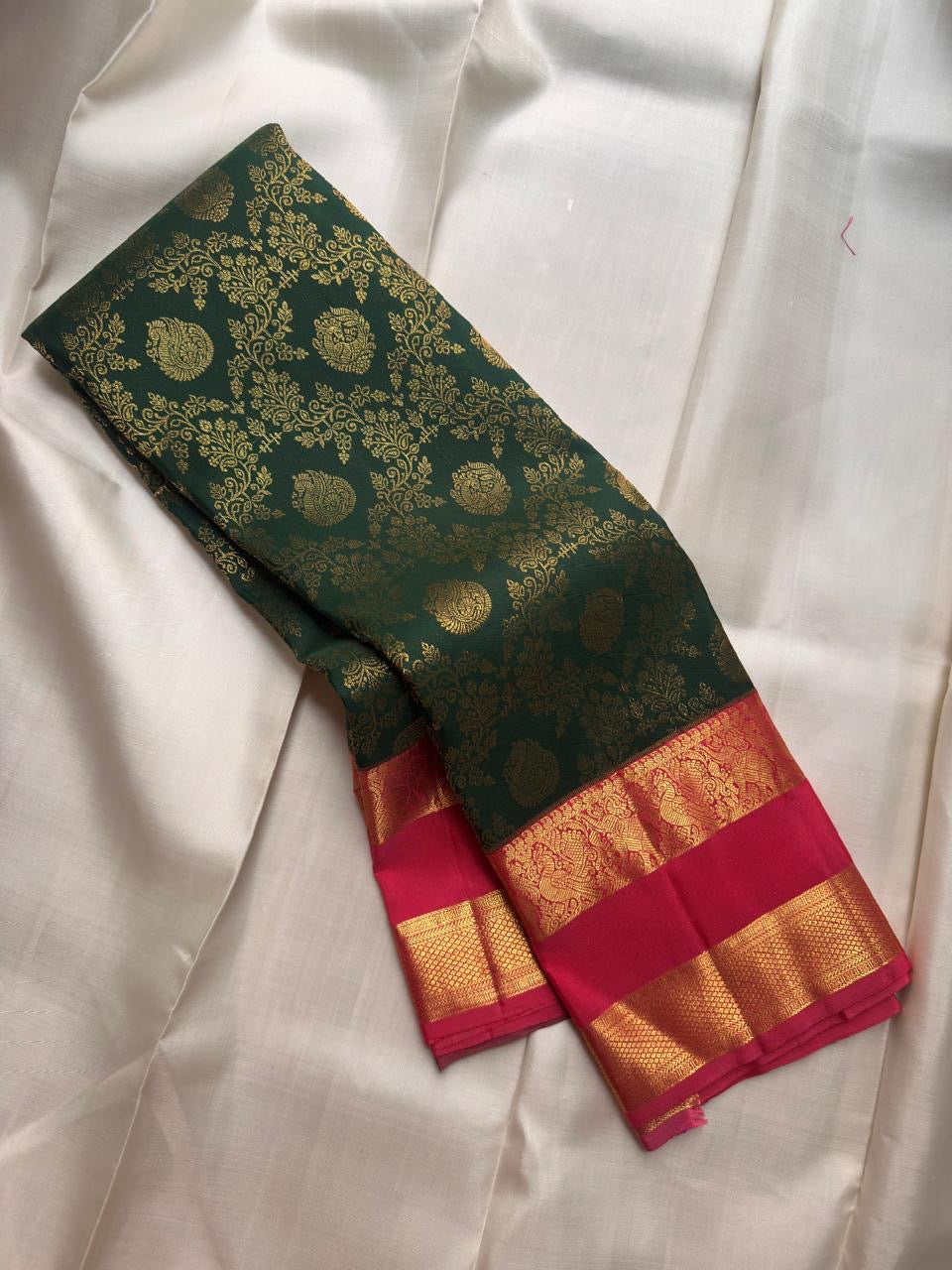 Deep forest-green Kanchipuram silk richly woven with curling floral and leafy classic gold zari brocade.