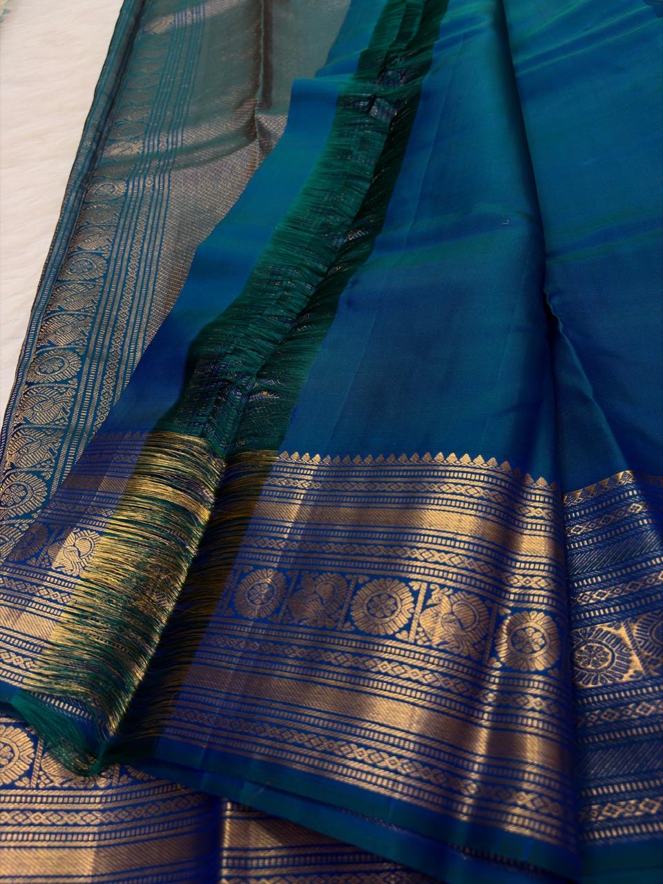 Peacock Blue Thazampoo Reku pure silk Kanchipuram saree, silk body, showing deep oceanic peacock blue with a teal-green glimmer, royal blue border accents and antique-gold zari