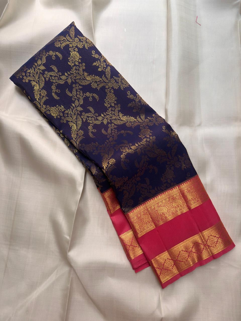Aubergine-purple Kanchipuram silk body richly woven with continuous floral and leafy classic gold zari brocade.