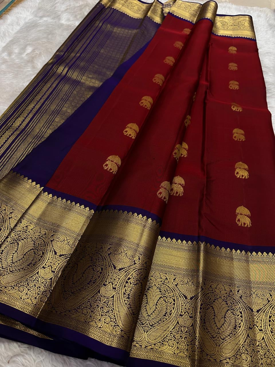 Open maroon silk body with measured spacing between ceremonial elephant zari buttas