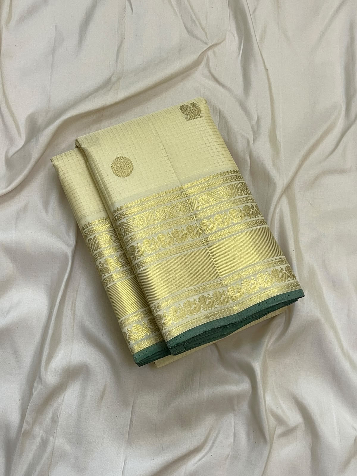 Ivory-and-gold seer pallu of a handwoven Kanjipuram silk saree with floral zari fields and ornamental bands