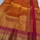 Close detail of the burnished orange silk and tightly ordered zari-grid surface