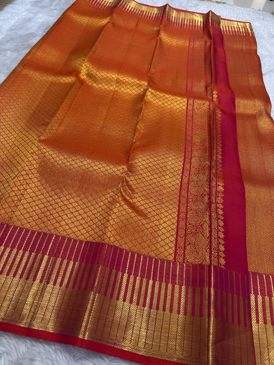 Close detail of the burnished orange silk and tightly ordered zari-grid surface