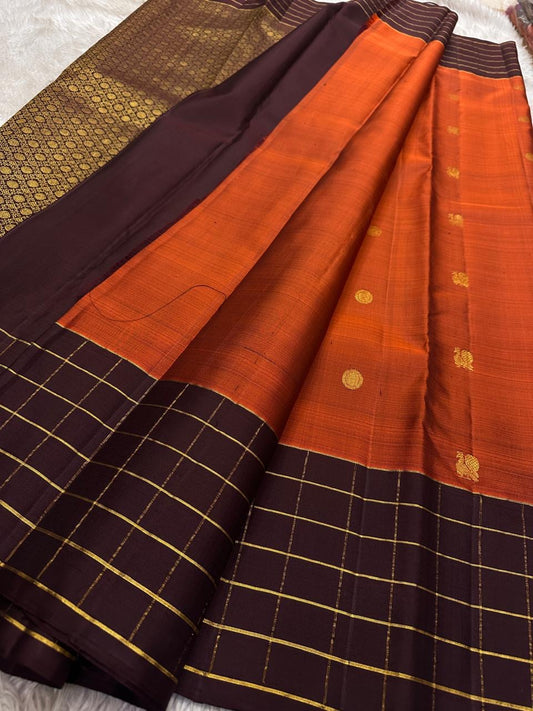 Gold-rich dark brown pallu with densely repeated circular motifs and fine gold checked outer section