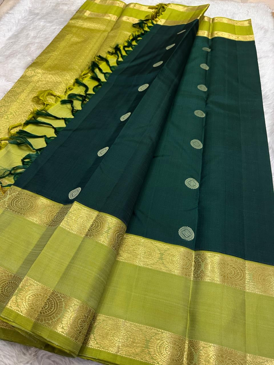 Close view of the luminous Kili Pachai Rettapet with large Chakram medallions woven in classic gold zari.