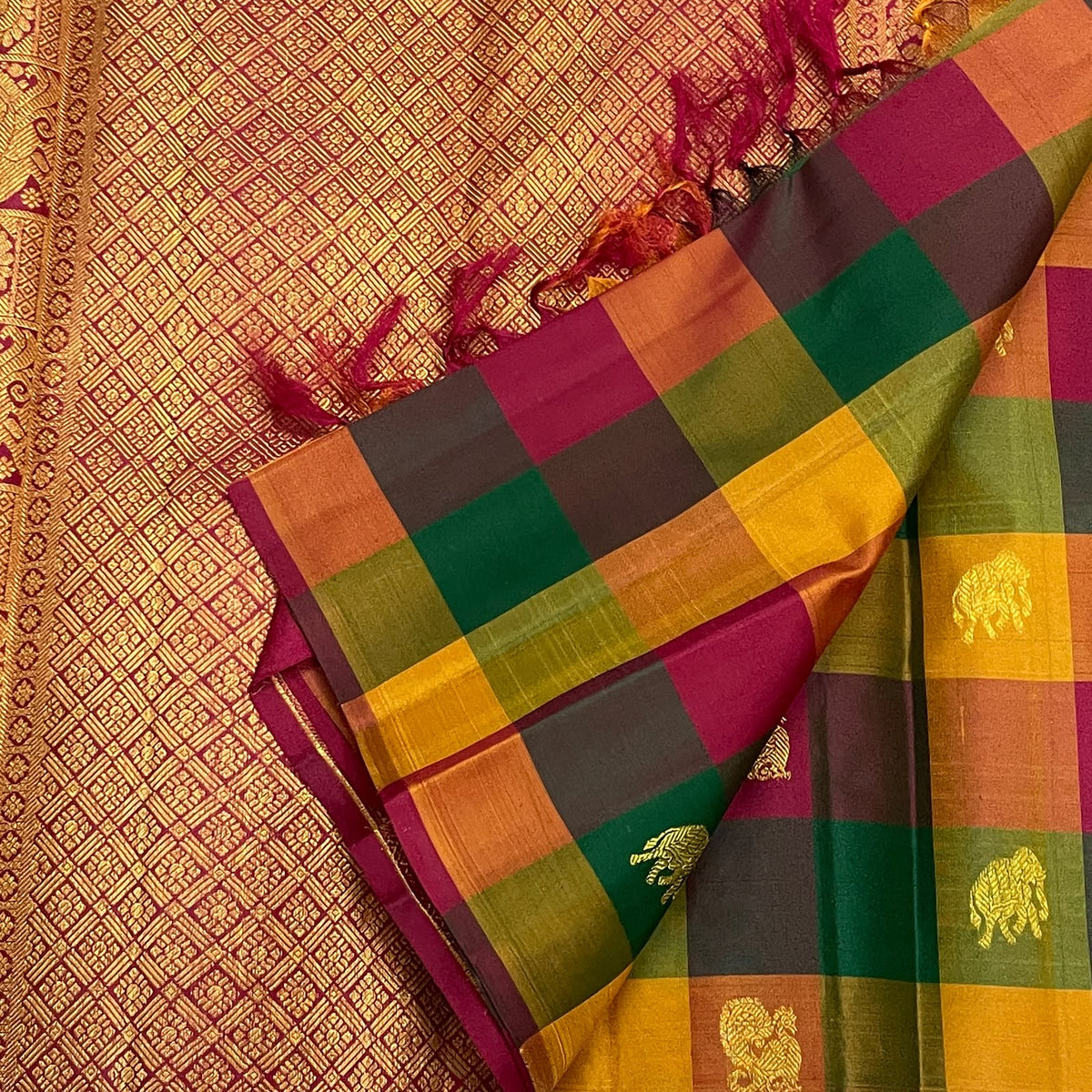 Checked Kanchipuram silk showing green, yellow, olive and pink squares with warm gold zari woven details.
