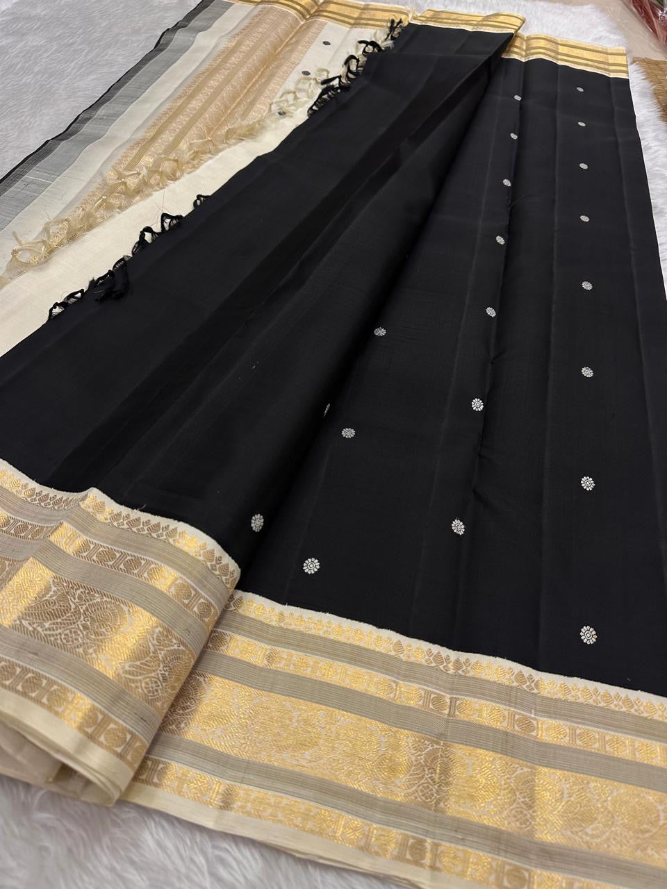Black Kancheepuram silk saree with ivory buttas and gold zari korvai border pallu detail