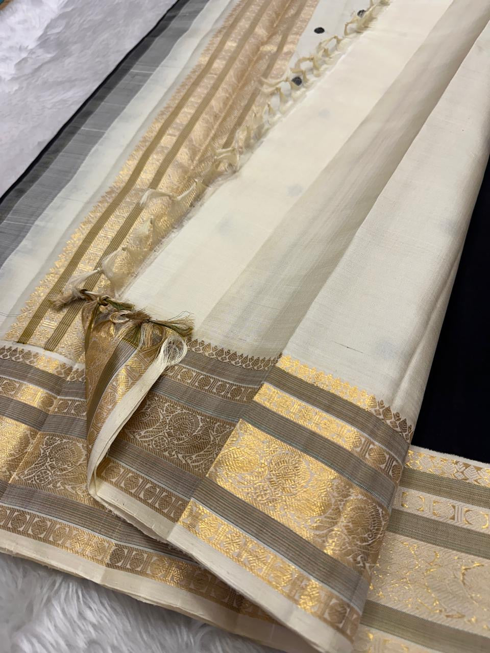 Black Kanjeevaram silk saree ivory butta antique gold zari korvai border closeup detail