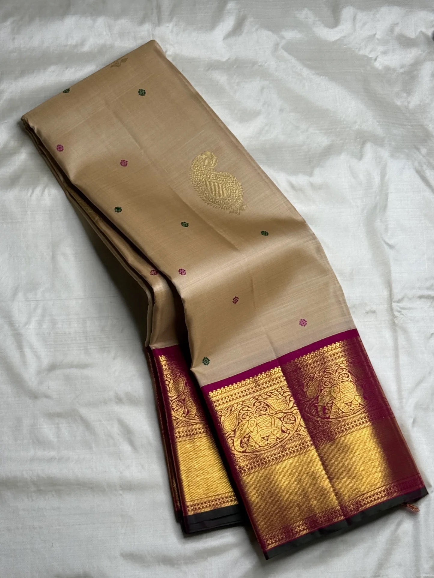 Reverse view showing the underside of the pallu and the contrast between the beige body and magenta border