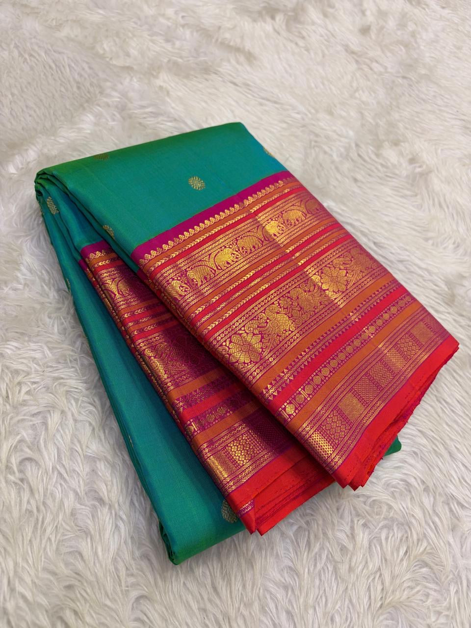 Kanchipattu silk saree in peacock teal with rani pink border Korvai Varisaipet weave traditional zari detail