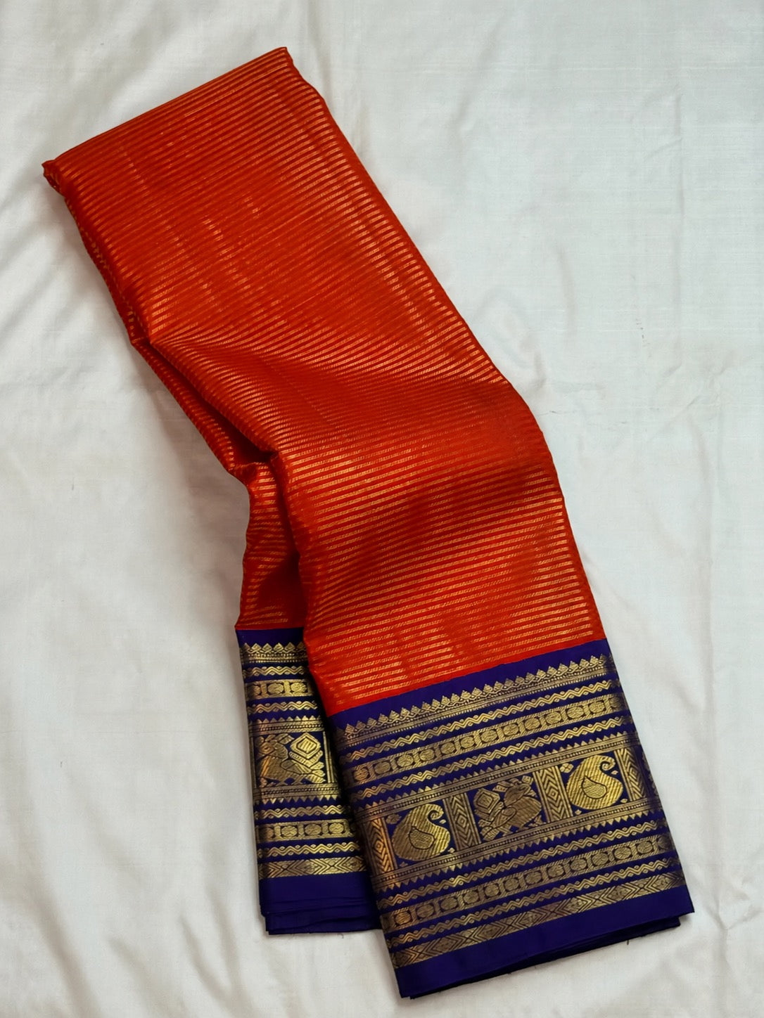 Kungumapoo orange Kanjivaram silk saree with royal blue border and pallu