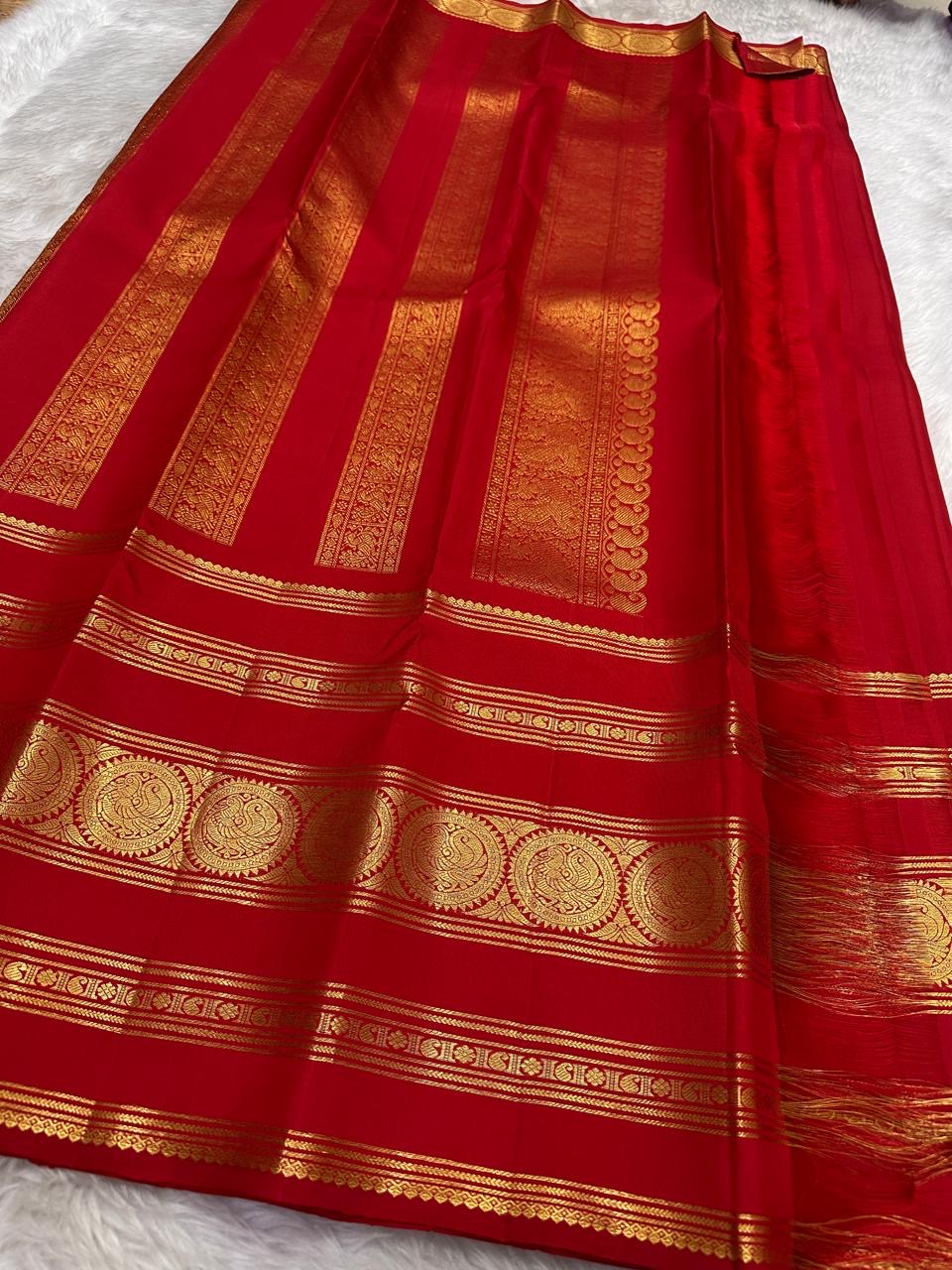 Kumkum red Kancheepuram Rettapet silk saree with gold zari border, folded view.