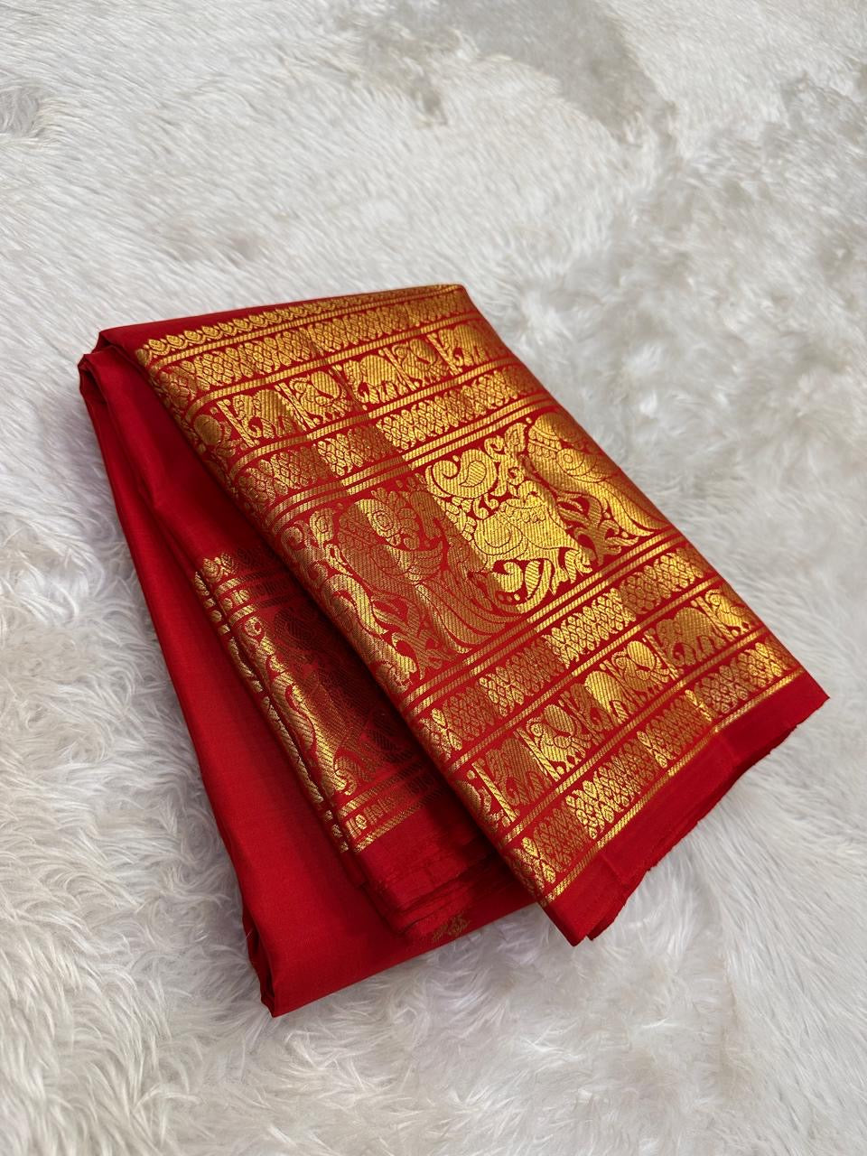 Kanchipattu silk saree in vibrant kumkum red with antique gold border Vanasringaram weave traditional zari detail