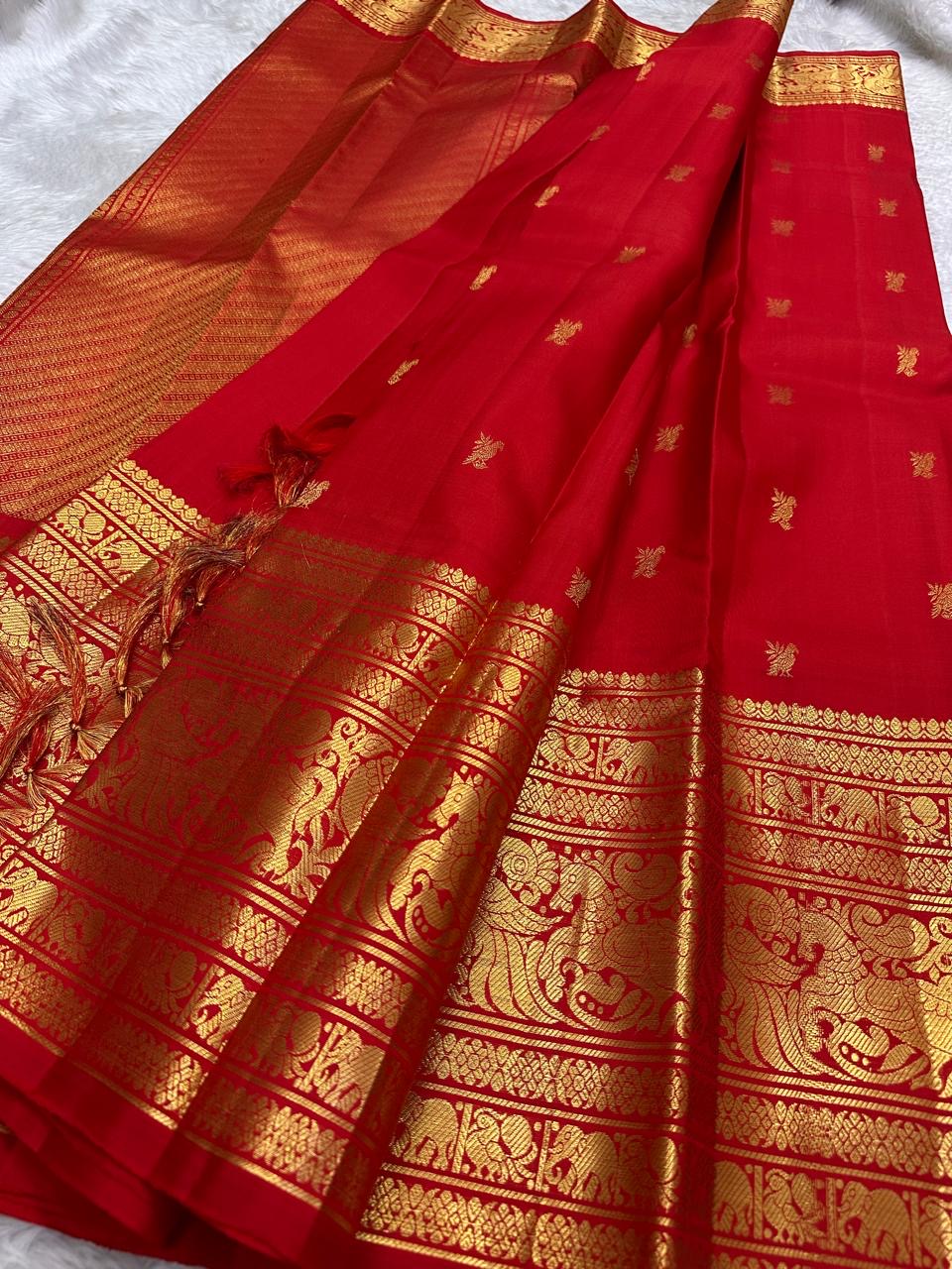Kanchipattu silk saree in vibrant kumkum red with antique gold border Vanasringaram weave traditional zari detail