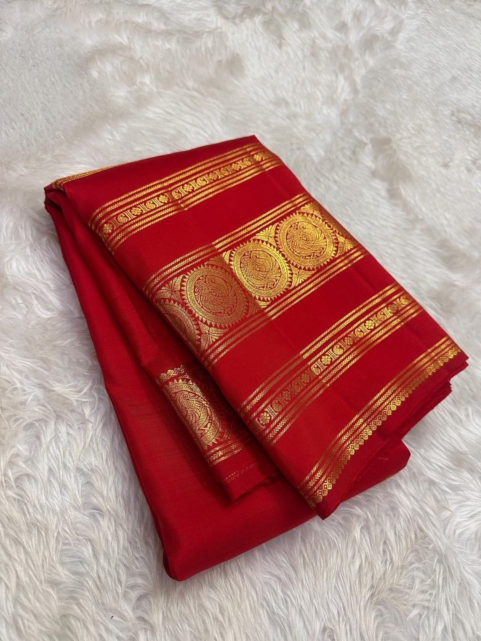 Kumkum red Kanjivaram pure silk saree showing the zari medallion border detail.
