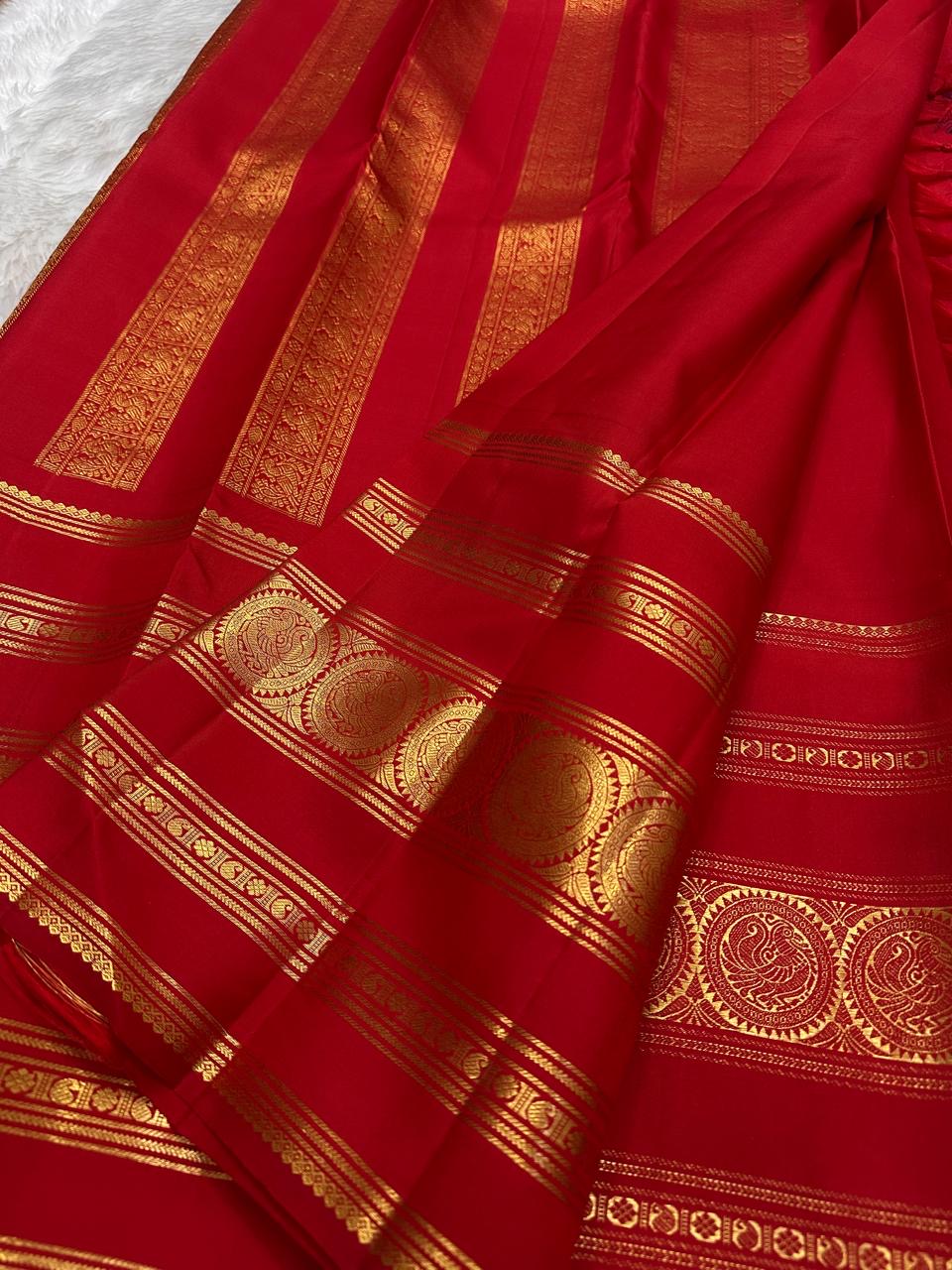 Kumkum red pure silk Kanjeevaram Rettapet saree, close view of the zari medallion border.