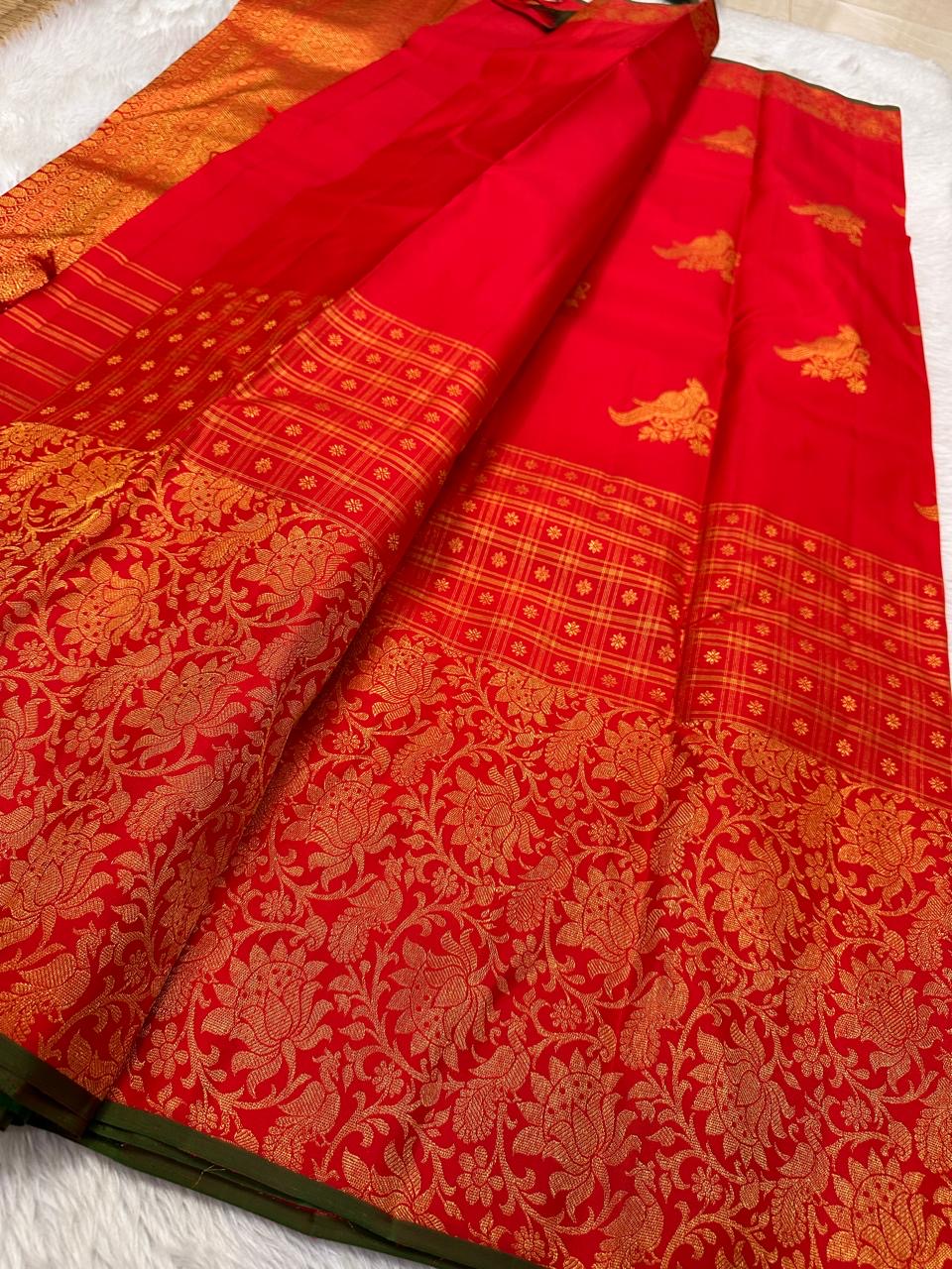 Narrow bottle-green selvedge finishing the rich red and gold Kanchi Pattu border.