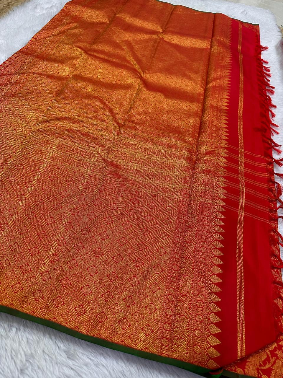 Kumkumam Red handwoven Pure Silk Kanchipuram Butta saree with a broad gold floral zari border and bottle-green edging.