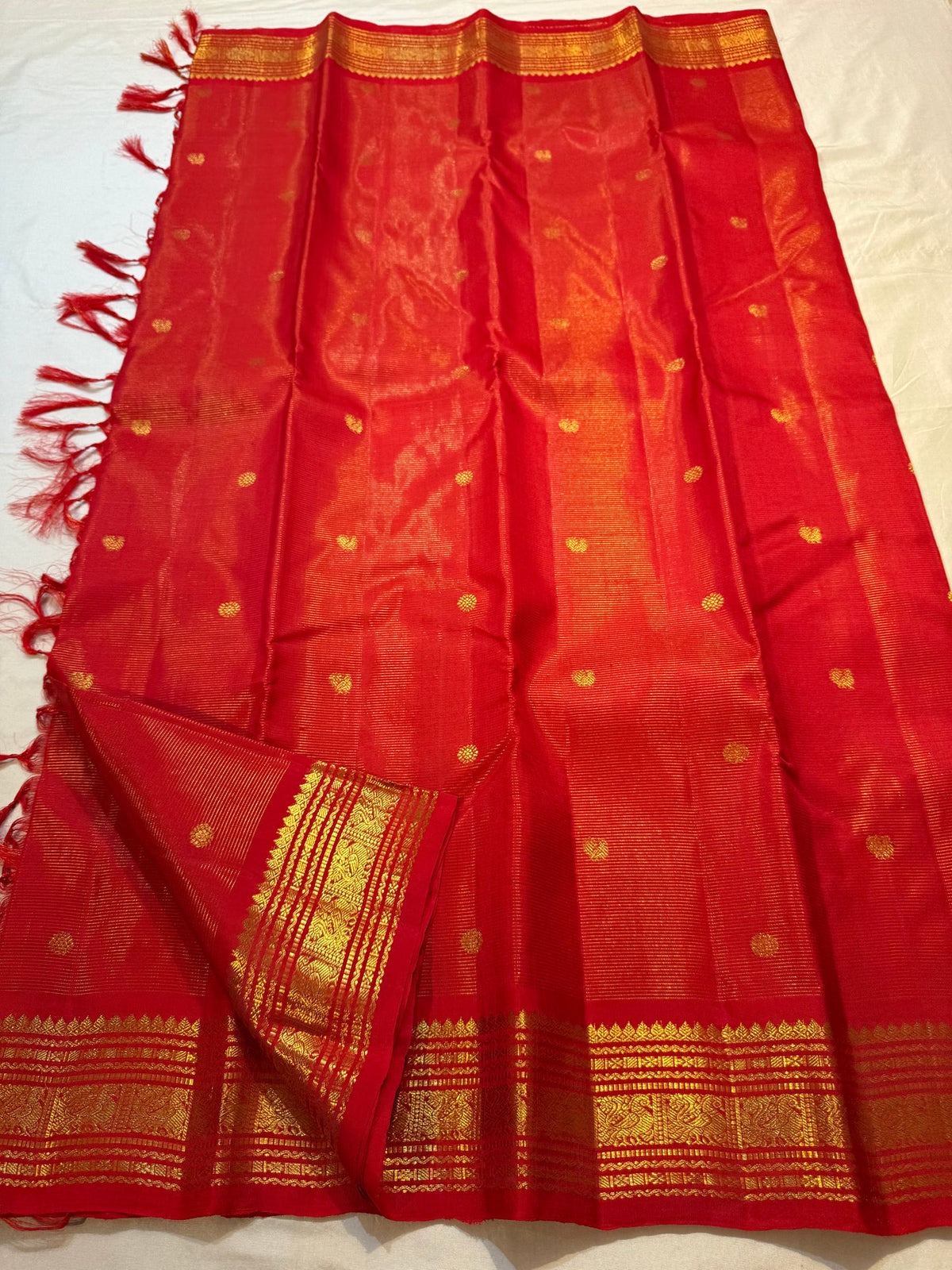 Close-up of the gold zari border on the Kumkumam red Kanjivaram silk saree