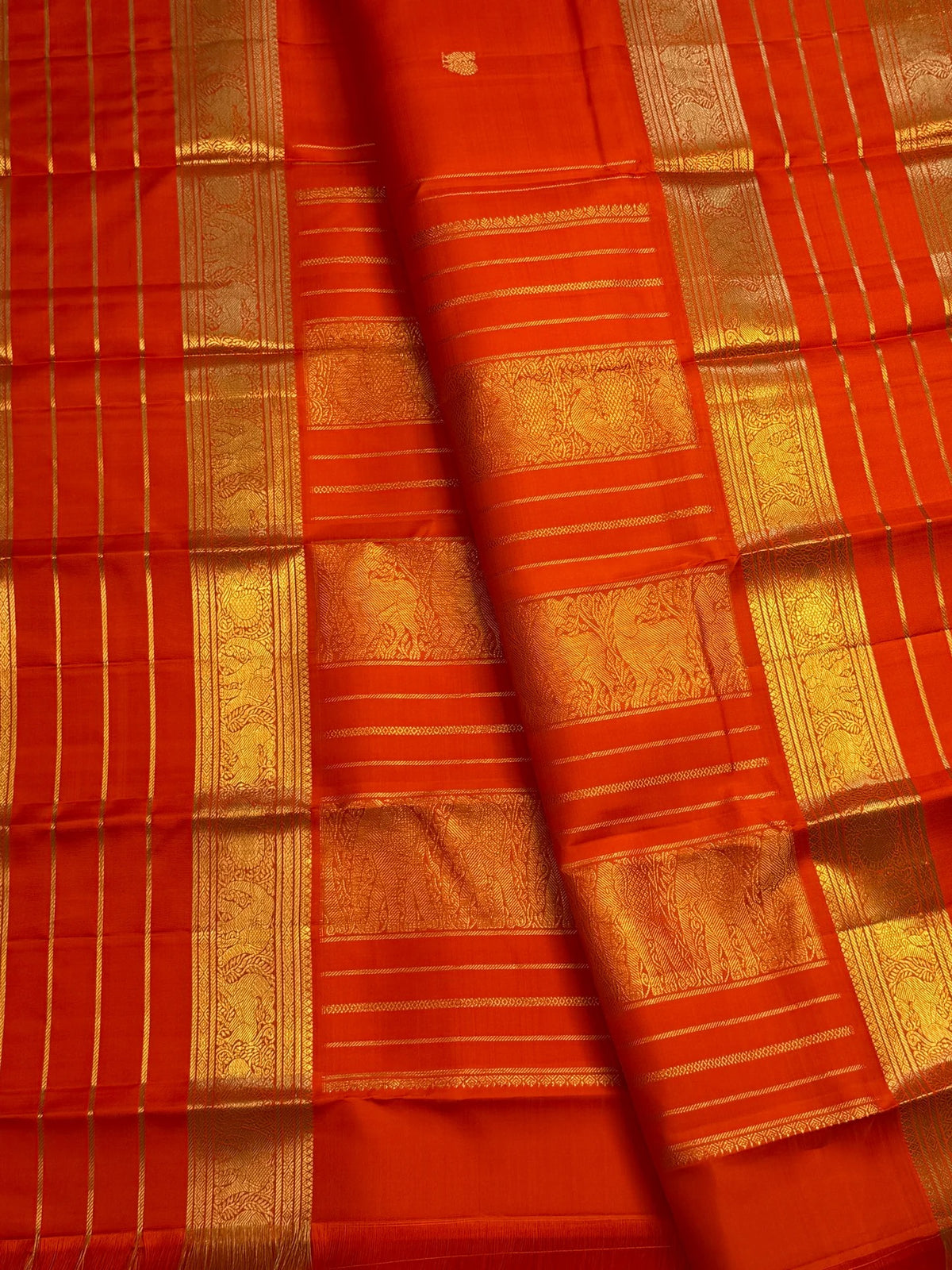 Handwoven jewel-toned orange Pure Silk Kanchipuram saree with a luminous plain body.