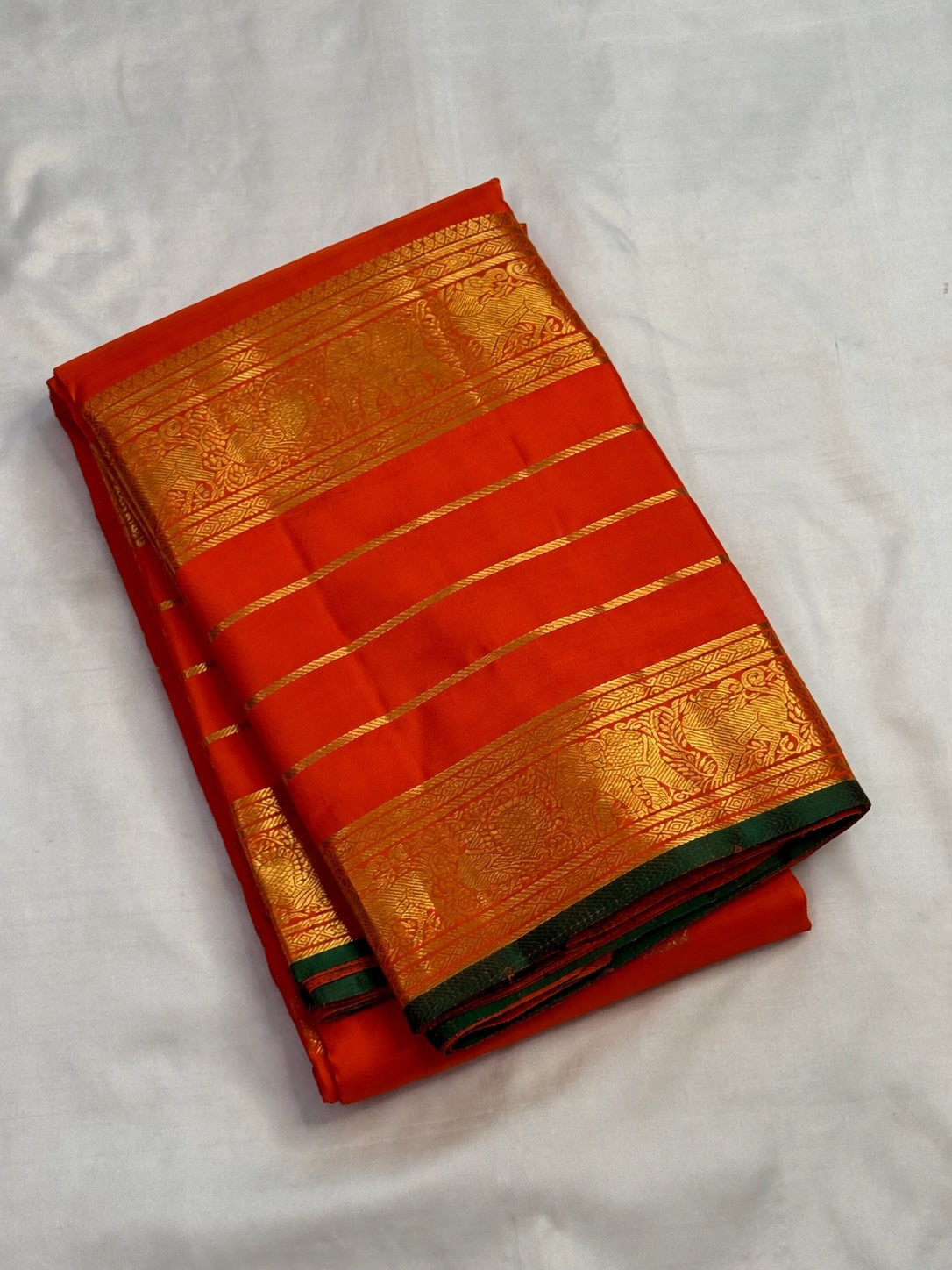 Grand dense zari pallu on a handwoven orange Kanchipuram silk saree with Yazhi, Yaanai and Mayil detailing.