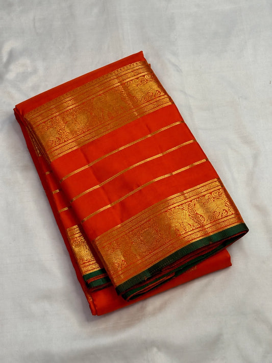 Grand dense zari pallu on a handwoven orange Kanchipuram silk saree with Yazhi, Yaanai and Mayil detailing.