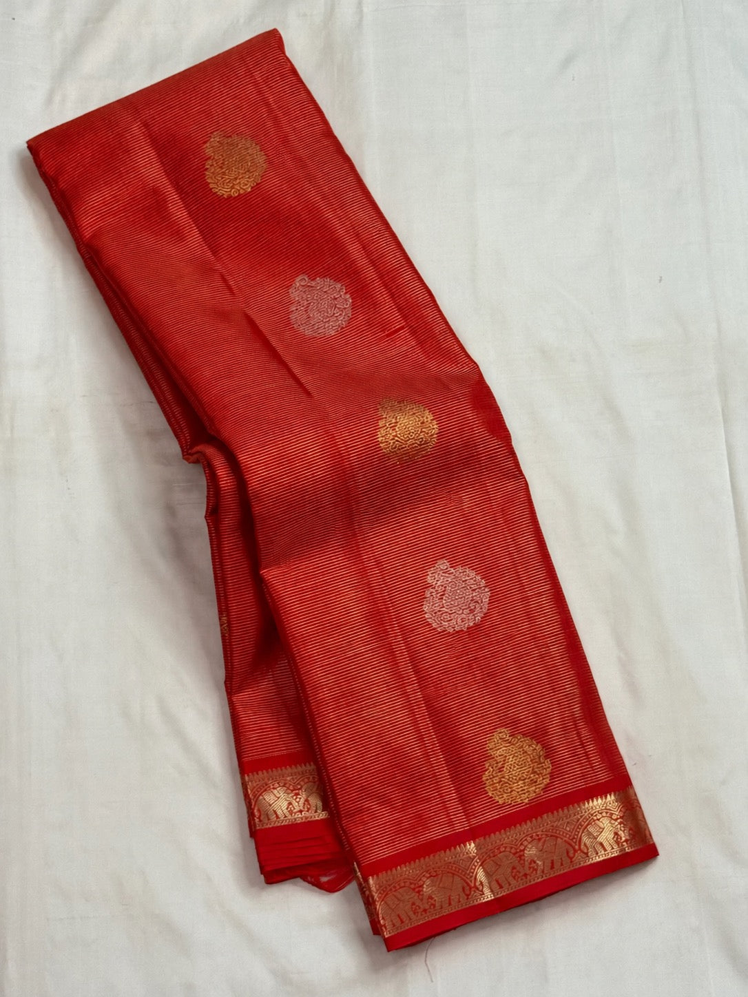 Full view of vermilion red Vairaoosi Kanchipuram silk with zari elephant edging and spaced paisley buttas